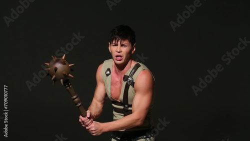 Handsome man in medieval hunting costume with mace attacks photo