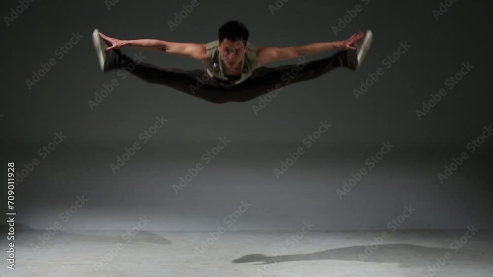 Asian acrobat man in medieval hunting costume jumps in studio Asian acrobat man in medieval hunting costume jumps in studio