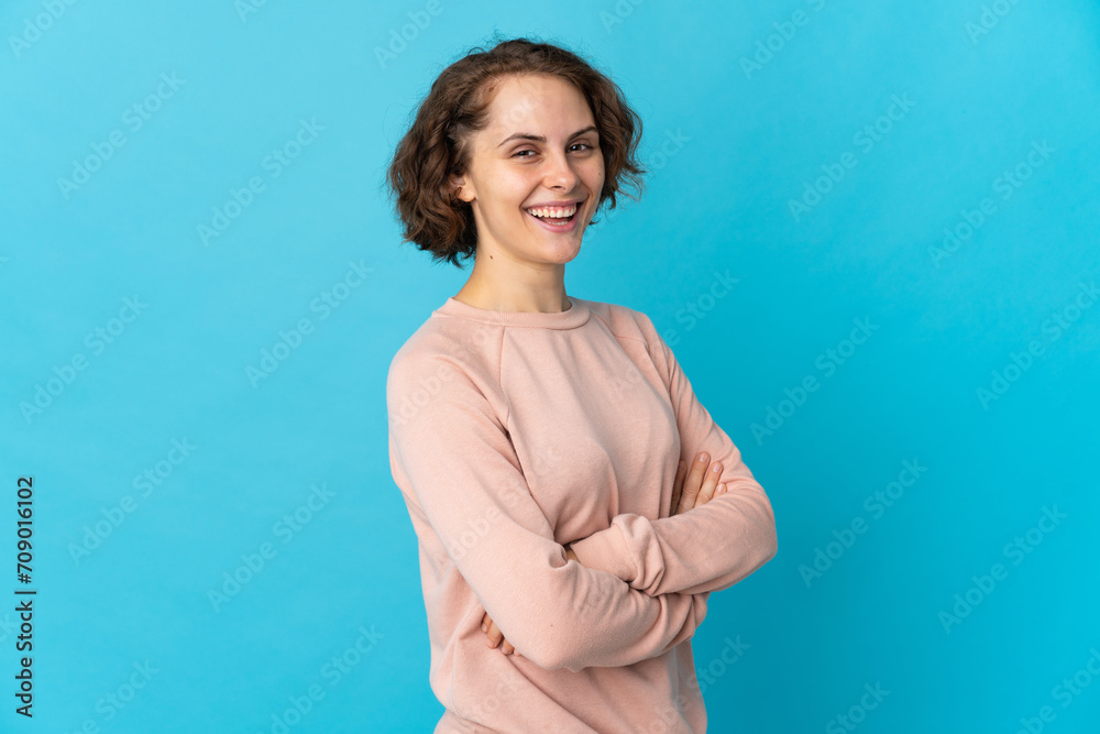 Young English woman isolated on blue background with arms crossed and looking forward Young English woman isolated on blue background with arms crossed and looking forward