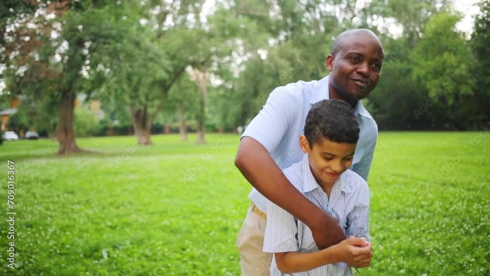 The father hugs and tickles his son in the park on a summer day The father hugs and tickles his son in the park on a summer day