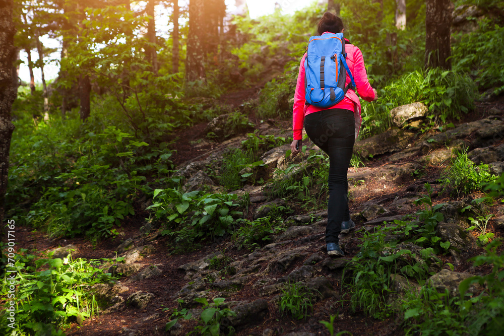 Young woman with backpack walk in mountain forest Young woman with backpack walk in mountain forest