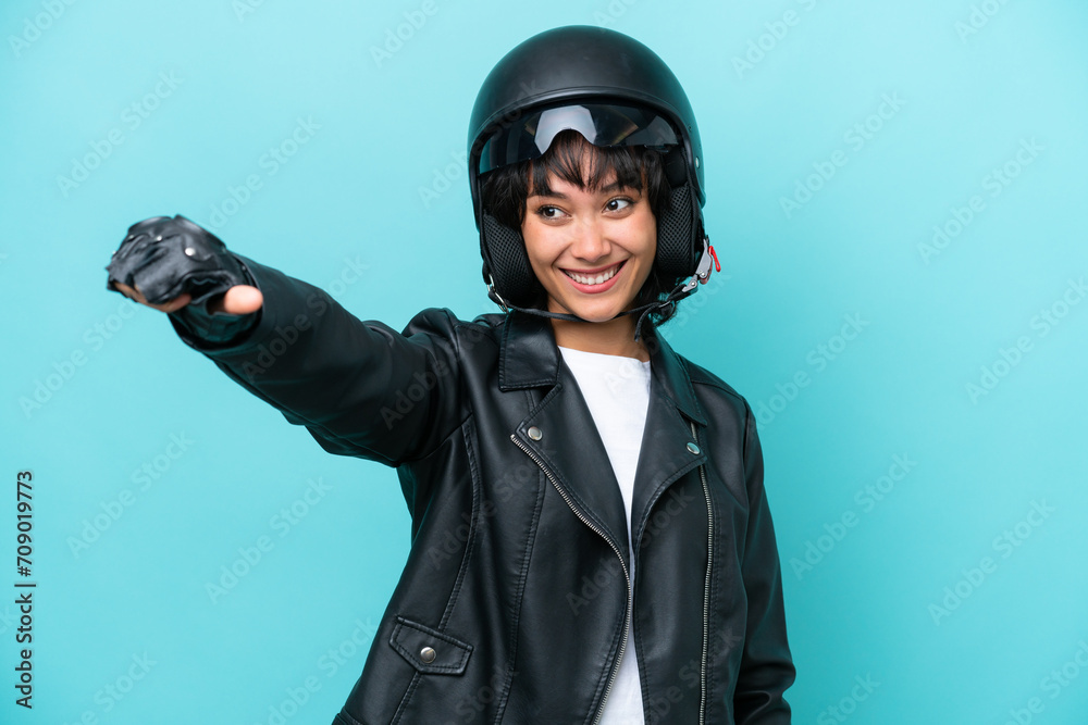 Young Argentinian woman with a motorcycle helmet isolated on blue background giving a thumbs up gesture Young Argentinian woman with a motorcycle helmet isolated on blue background giving a thumbs up gesture