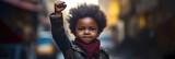Young girl with fist raised high, symbolizing hope and strength. African American History or Black History Month concept. Celebrated annually in February in the USA and Canada