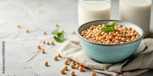 Soybeans in Bowl with Glass of Soy Milk, copy space. A nutritious setup of soybeans, fresh soy milk on a white textured table background.