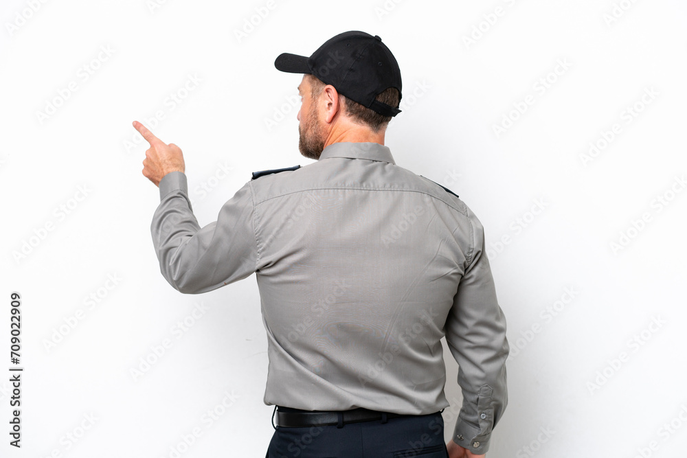 Middle age security man isolated on white background pointing back with the index finger Middle age security man isolated on white background pointing back with the index finger