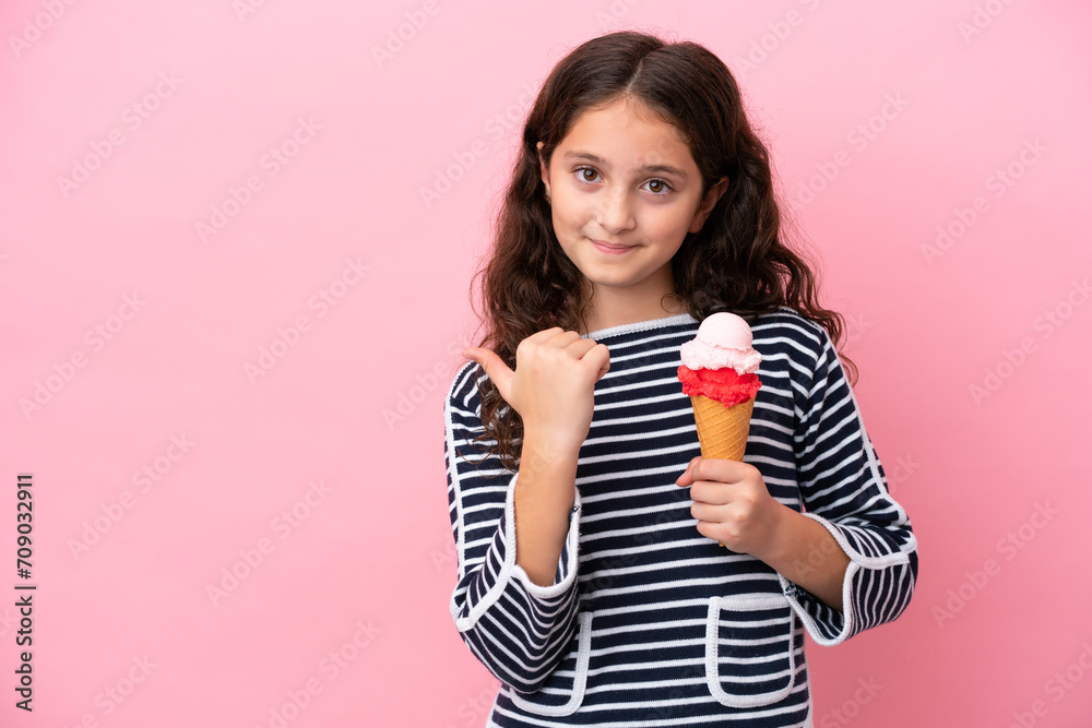 Little caucasian girl holding an ice cream isolated on pink background pointing to the side to present a product Little caucasian girl holding an ice cream isolated on pink background pointing to the side to present a product