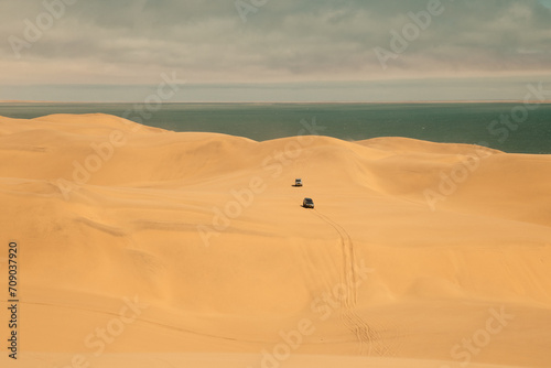 Car driving the sand dunes in Sandwich Harbour Historic, Namibia