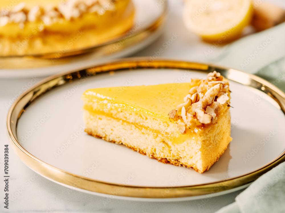 Piece of delicious lemon tart or lemon cake, modernly decorated with walnuts on aesthetic plate. Aesthetic of traditional classic french lemon pie with lemon curd recipe. Copy space