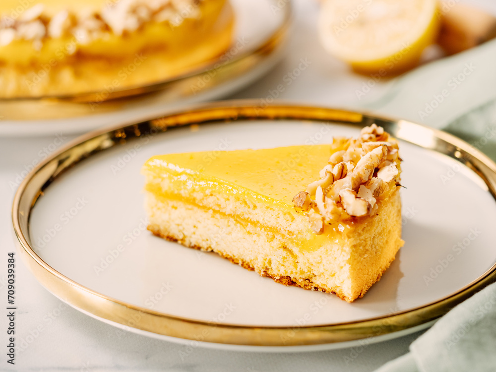 Piece of delicious lemon tart or lemon cake, modernly decorated with walnuts on aesthetic plate. Aesthetic of traditional classic french lemon pie with lemon curd recipe. Copy space Piece of delicious lemon tart or lemon cake, modernly decorated with walnuts on aesthetic plate. Aesthetic of traditional classic french lemon pie with lemon curd recipe. Copy space