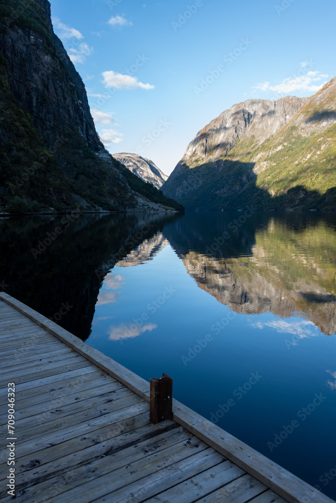 Symmetrical reflections of the fjord, in the afternoon, view from Gudvangen ferry pier
