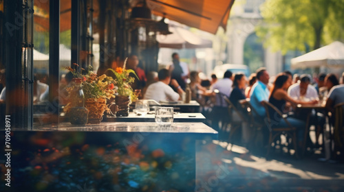 An outdoor restaurant patio bustles with diners enjoying meals and conversation in the warm, glowing sunlight of the day. photo