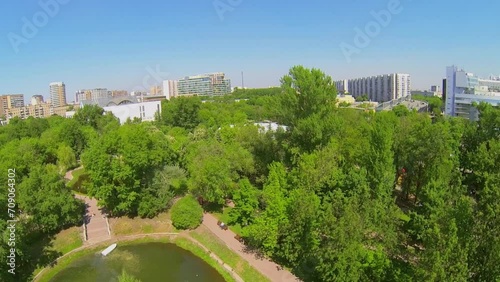 Cityscape with pond in public garden at sunny spring day.  photo