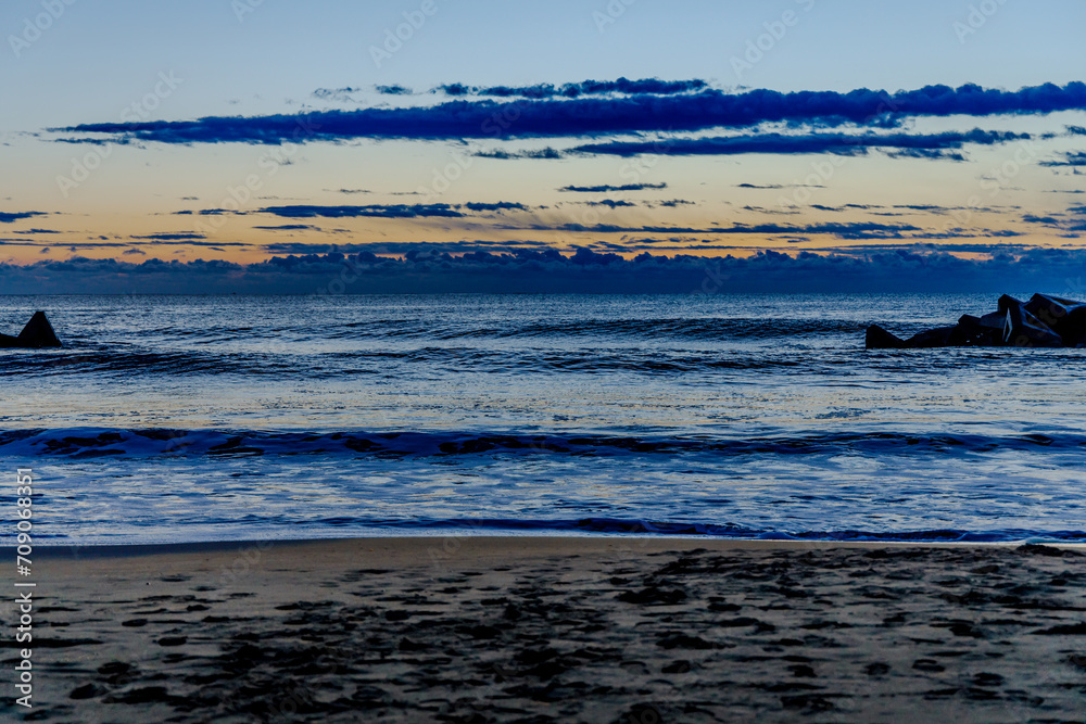 Sunrise over the ocean and blue sky with clouds