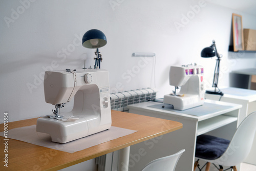 Sewing machine on the table in the sewing workshop. Sewing accessories.