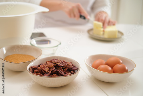 Closeup on ingredients for baking in the kitchen, woman's hands. Process of cooking pecan pie in home kitchen for American Thanksgiving Day.