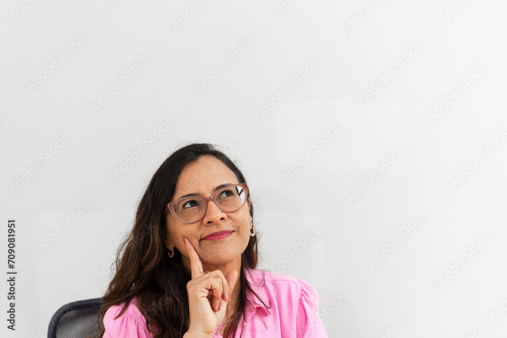 A psychopedagogue wearing pink clothes, in her office, sitting, thinking. helps with school performance. A psychopedagogue wearing pink clothes, in her office, sitting, thinking. helps with school performance.