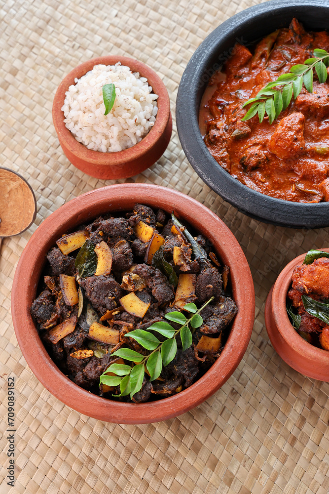 Spicy red beef fry curry and brown rice South Indian dish Kerala, India. side of Ghee rice, Appam, Parotta, Puttu. traditional Christian Muslim feast dish. Buffalo roast, meat pepper fry with coconut.