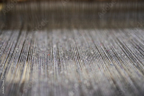 Woolen strings in textile machine from 19th century. Close up.