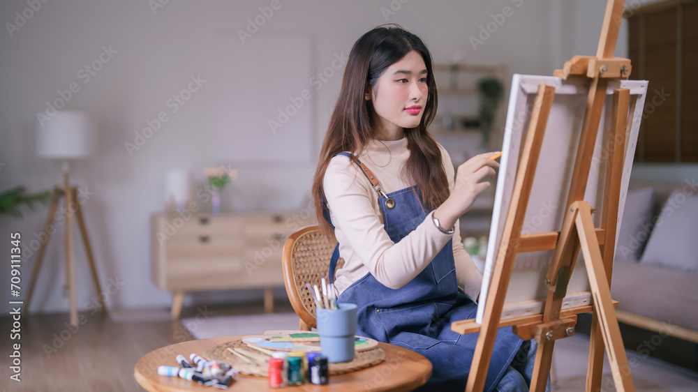Young asian female artist working to drawing and painting for create creative artwork on the canvas Young asian female artist working to drawing and painting for create creative artwork on the canvas