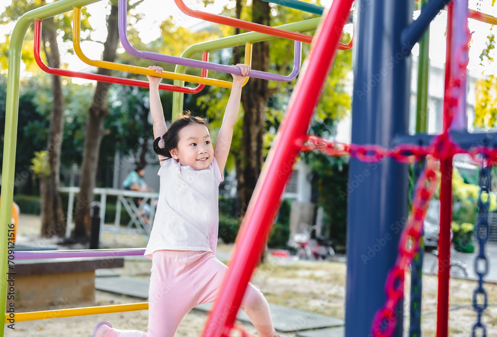 Fototapeta premium Happy child girl playing at outdoor playground in the park on , outdoor or playground