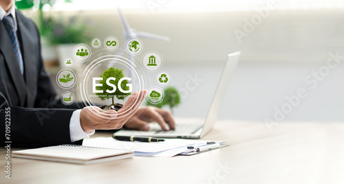 Businessman holding a green tree with esg icon. Concept of esg, environmental, social and governance responsibility. sustainable development green business photo