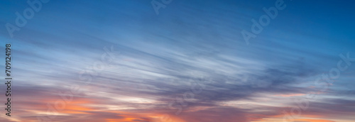 A large panorama of the sky before sunset, low striped clouds of bright red color photo