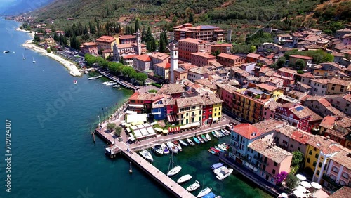 Scenic Lake Lago di Garda, Italy, aerial video of fishing village with colorful houses and boats - Castelletto di Brenzone.
 photo