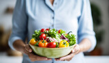 Aged woman smiling happily and holding a healthy vegetable salad bowl on blurred kitchen background, with copy space