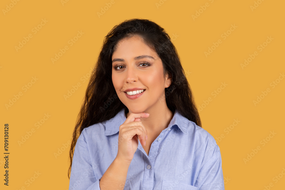 A confident young woman with wavy dark hair and a radiant smile, posing thoughtfully A confident young woman with wavy dark hair and a radiant smile, posing thoughtfully