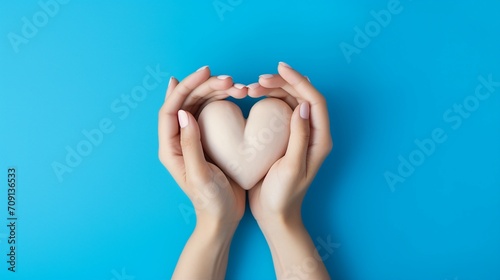 Hands Forming a Heart Shape, Symbolizing Love and Support in Healthcare. Cropped Top Photo Over Blue Background, Conceptualizing the Essence of Saving Lives and Providing Medical Assistance