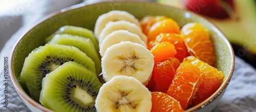 Kiwi, banana, and orange in child's fruit dessert.