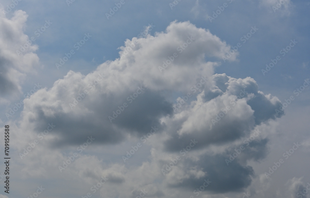 White Cumulus clouds under a pale blue sky are visible on a sunny day White Cumulus clouds under a pale blue sky are visible on a sunny day