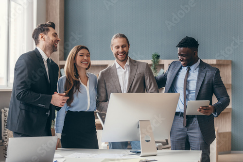 Group of business people looking happy while having quick meeting in the office together