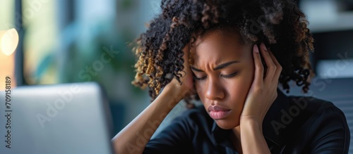 A fatigued consultant, experiencing burnout and with a headache from long hours in customer service and online support, including telemarketing and contact with customers, particularly for a black photo