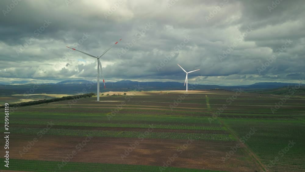 Aerial view of industrial windmill rotating in rural area in Italy Aerial view of industrial windmill rotating in rural area in Italy