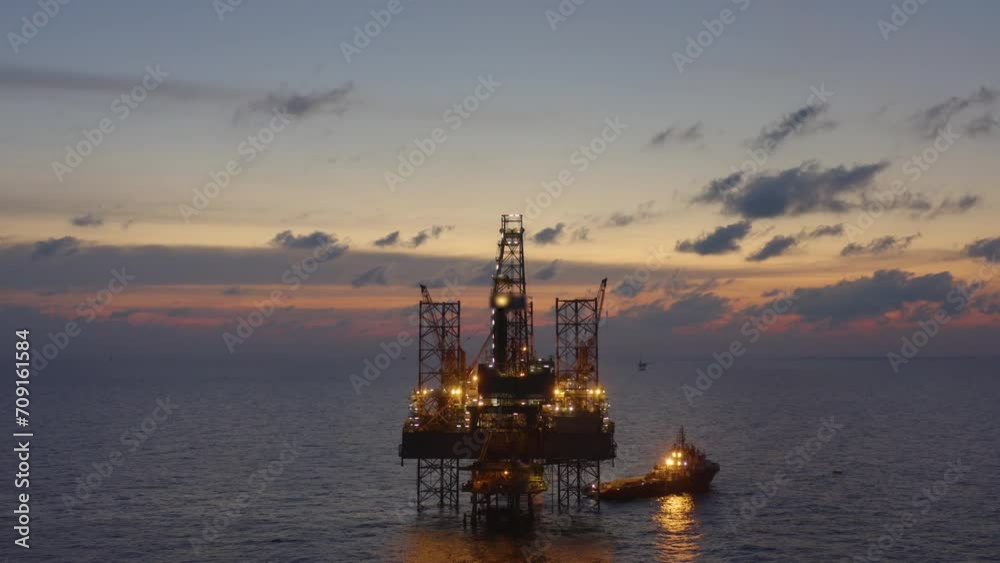Aerial view of silhouette offshore jack up drilling rig during sunset - oil and gas industry Aerial view of silhouette offshore jack up drilling rig during sunset - oil and gas industry