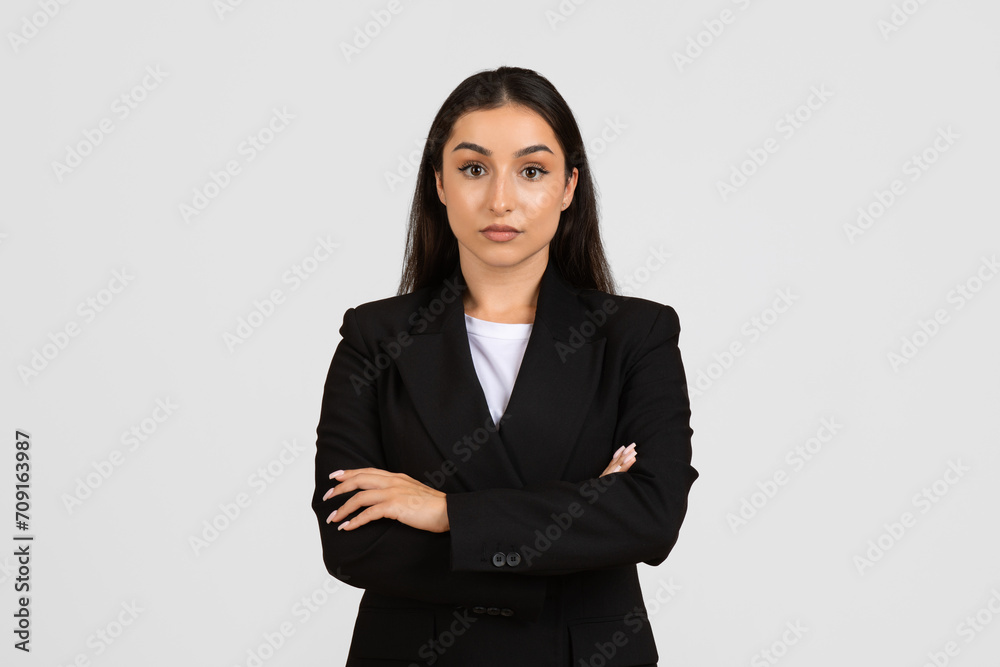 Entrepreneurship. Portrait of businesswoman in black jacket, posing looking at camera over gray studio background Entrepreneurship. Portrait of businesswoman in black jacket, posing looking at camera over gray studio background