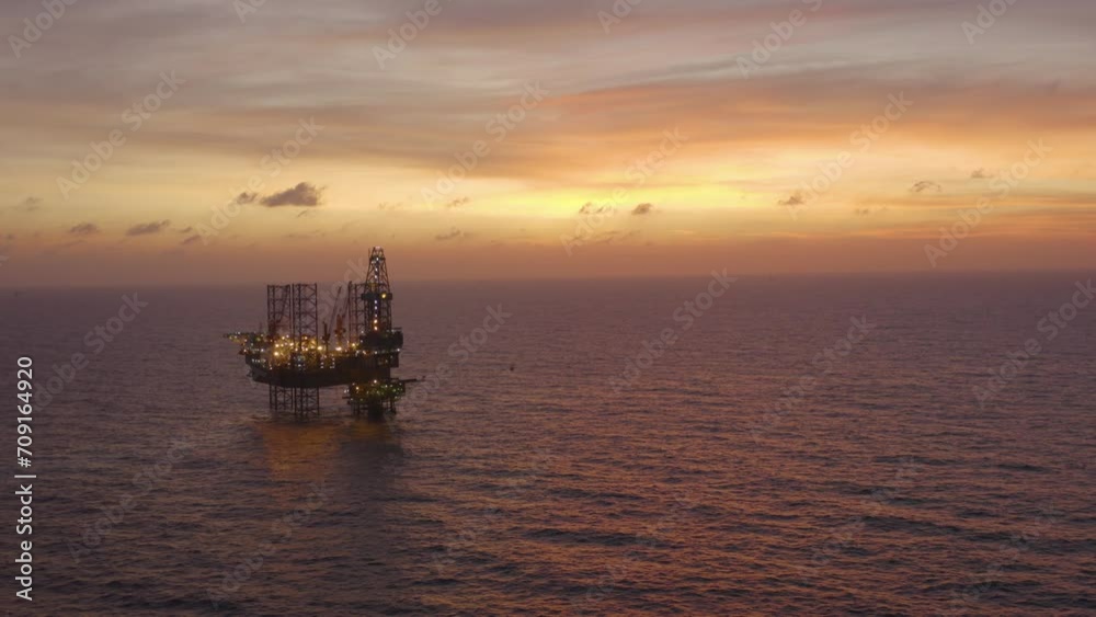 Aerial view of silhouette offshore jack up drilling rig during sunset - oil and gas industry Aerial view of silhouette offshore jack up drilling rig during sunset - oil and gas industry