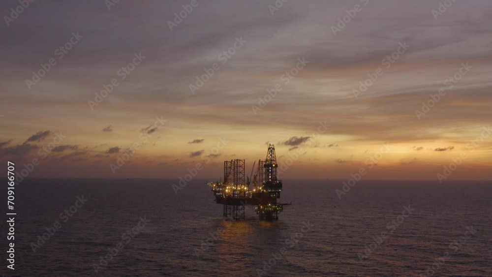 Aerial view of silhouette offshore jack up drilling rig during sunset - oil and gas industry Aerial view of silhouette offshore jack up drilling rig during sunset - oil and gas industry