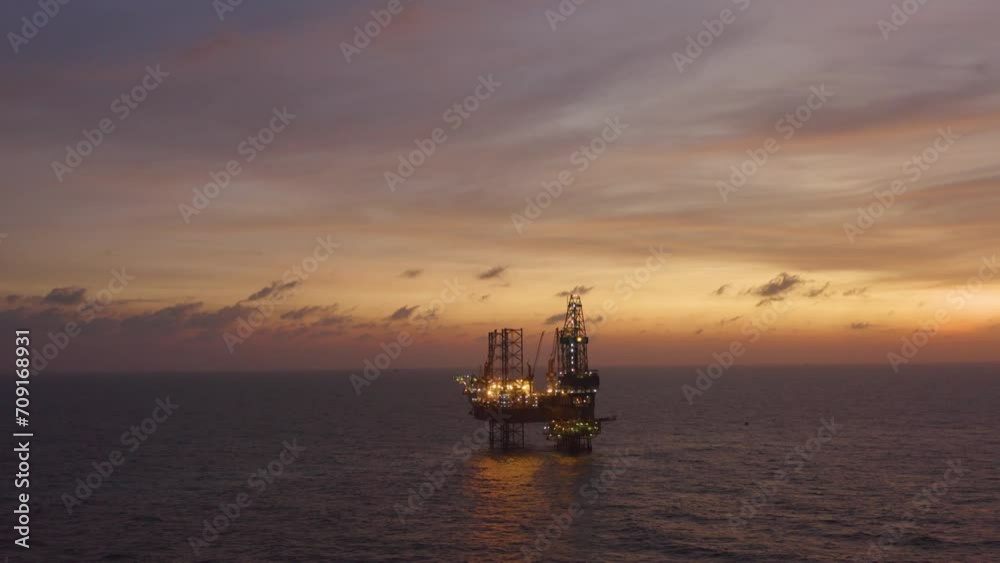 Aerial view of silhouette offshore jack up drilling rig during sunset - oil and gas industry Aerial view of silhouette offshore jack up drilling rig during sunset - oil and gas industry