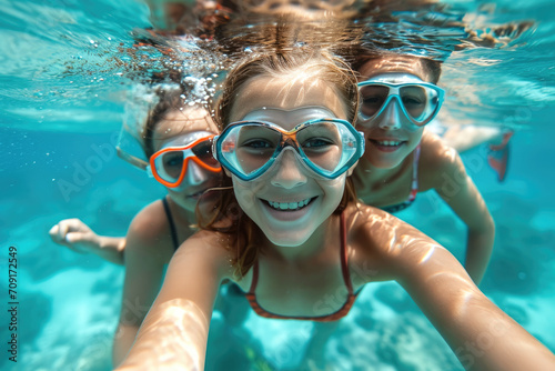 Niños buceando junto a peces en una playa de Aguas cristalinas en sus vacaciones familiares de verano photo