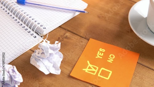 Coffee and a notebook on a brown wooden table under table lamp with warm light, slow motion video.

