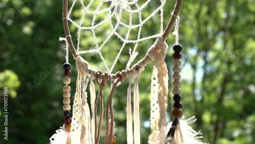 Dream catcher and green trees on the background.
