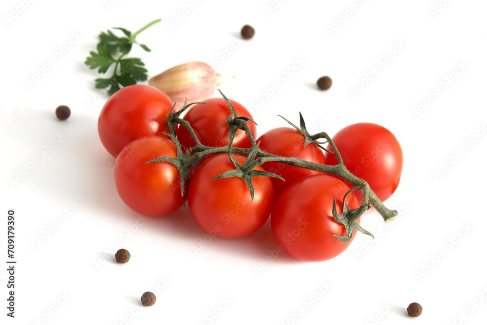 Cherry tomatoes lie on a white background with a sprig. Cherry tomatoes lie on a white background with a sprig.