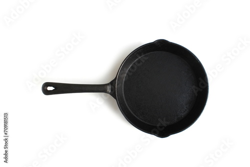 A black cast iron frying pan lies on a white background.