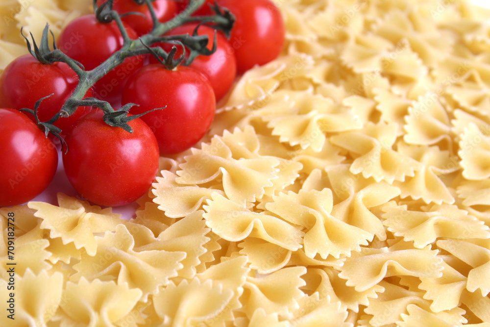Background of pasta and cherry tomatoes on a branch.	