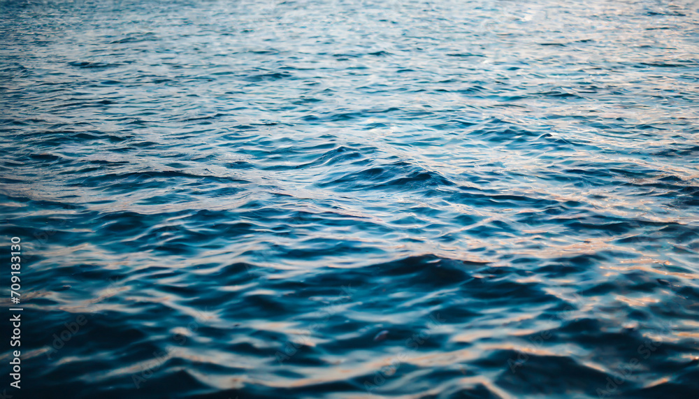 Fototapeta premium Crystal-clear water surface reflecting vibrant blue sky, symbolizing purity, tranquility, and serenity. Ideal for concepts of clarity and calmness