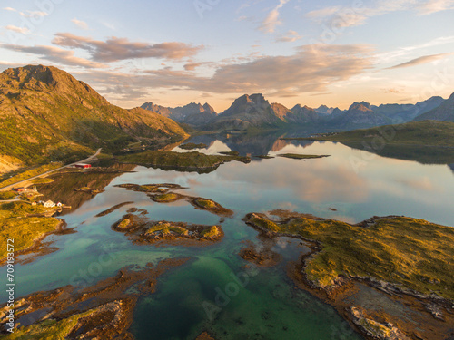 sunset view of Lofoten, Norway from above, with high mountains, the fjord of Selfjord, colorful sky. fredvang bridge road towards road E10.
