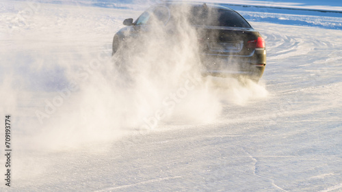 Car turns sharply on slippery road, leaving trail of snow, Car at high speed moves on slippery road, icy road, drifting car in freezing weather, Auto ice racing, Tinted, Selective Focus, Sun Flare