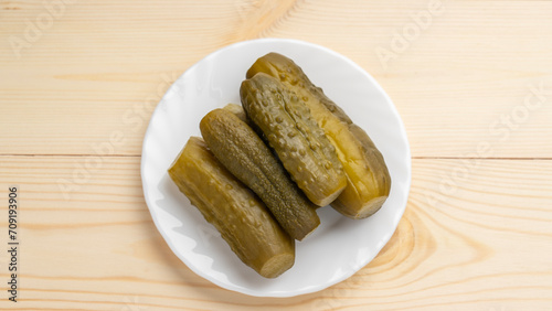 Pickled lightly salted cucumbers in white plate on wooden background, Lenten food in Great Lent of Christians